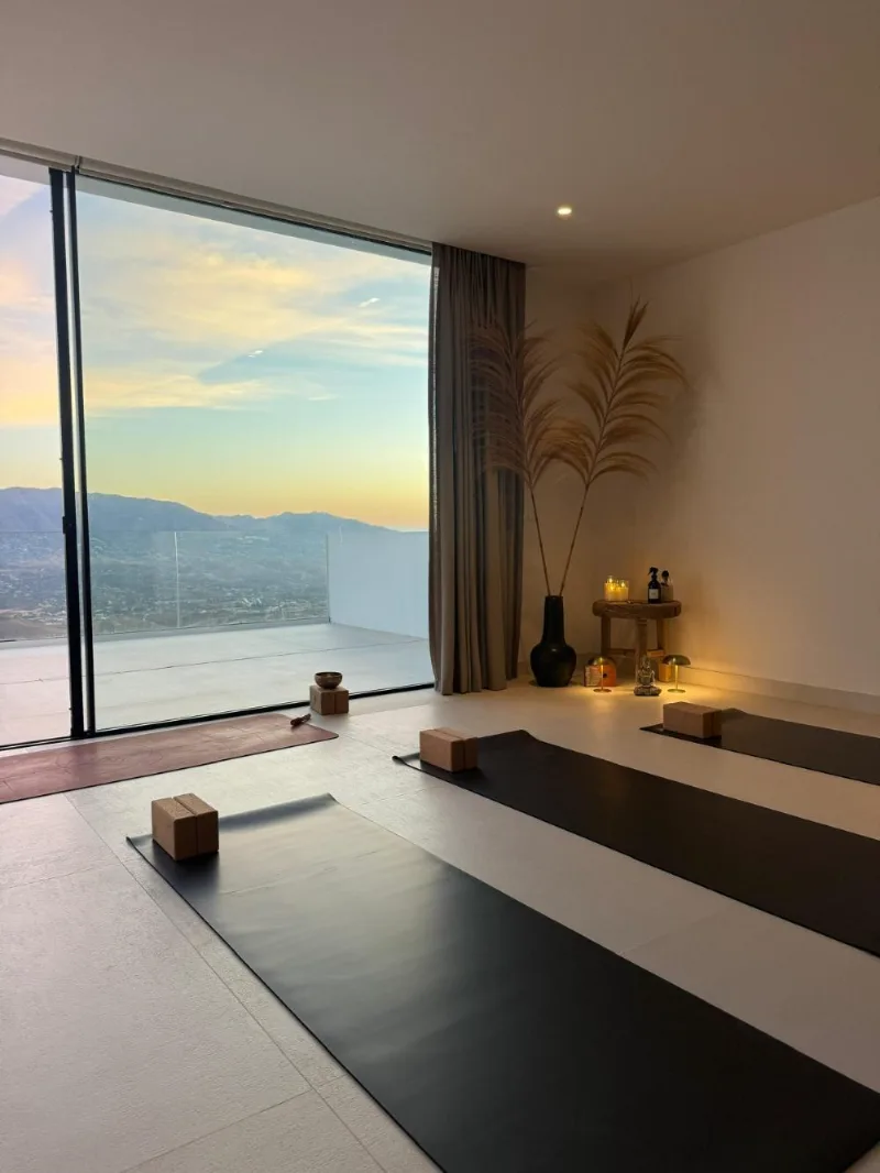Sala de yoga preparada con vistas a la montaña al amanecer